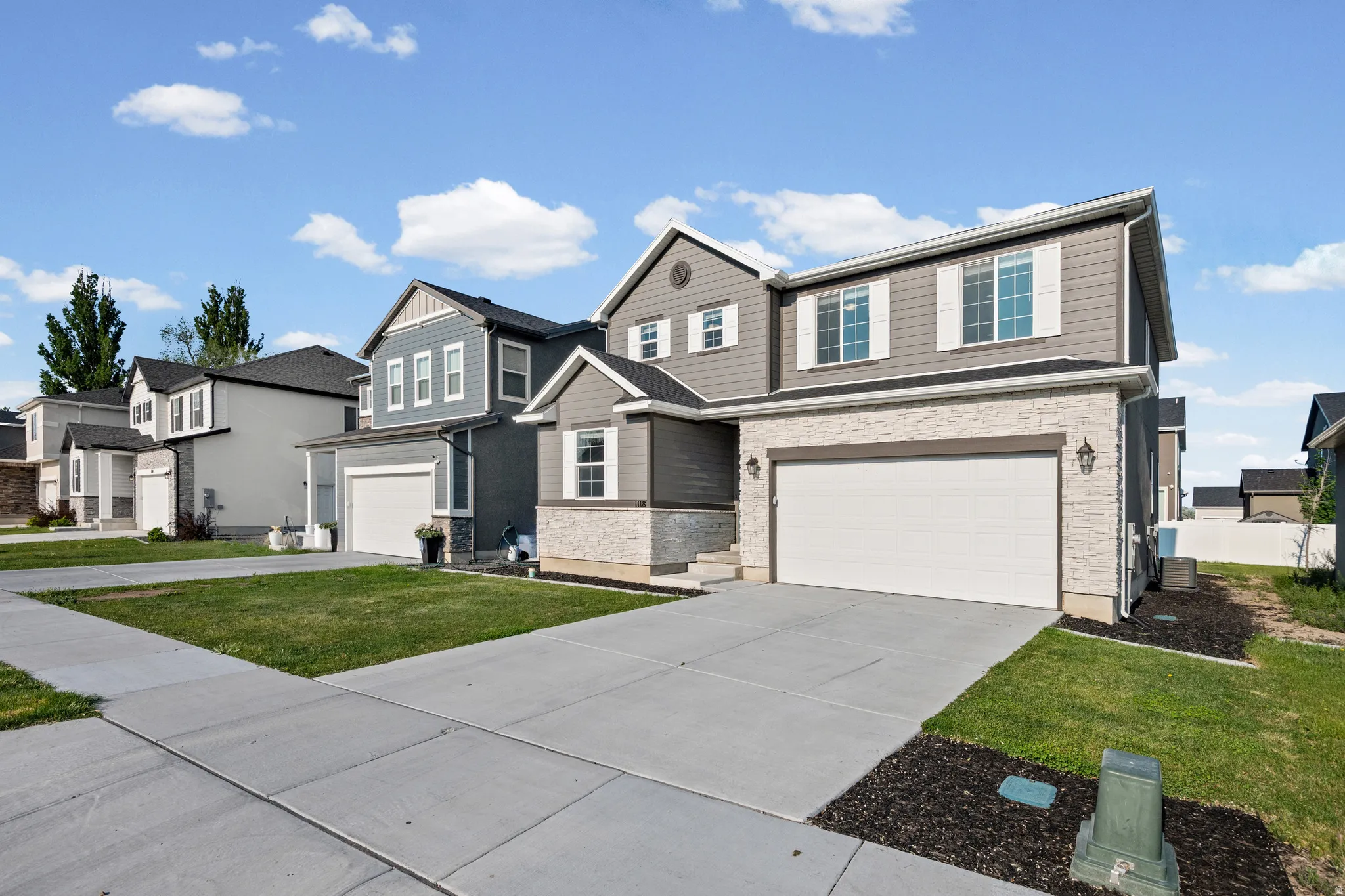 Contemporary home with stone facade accents and neutral siding