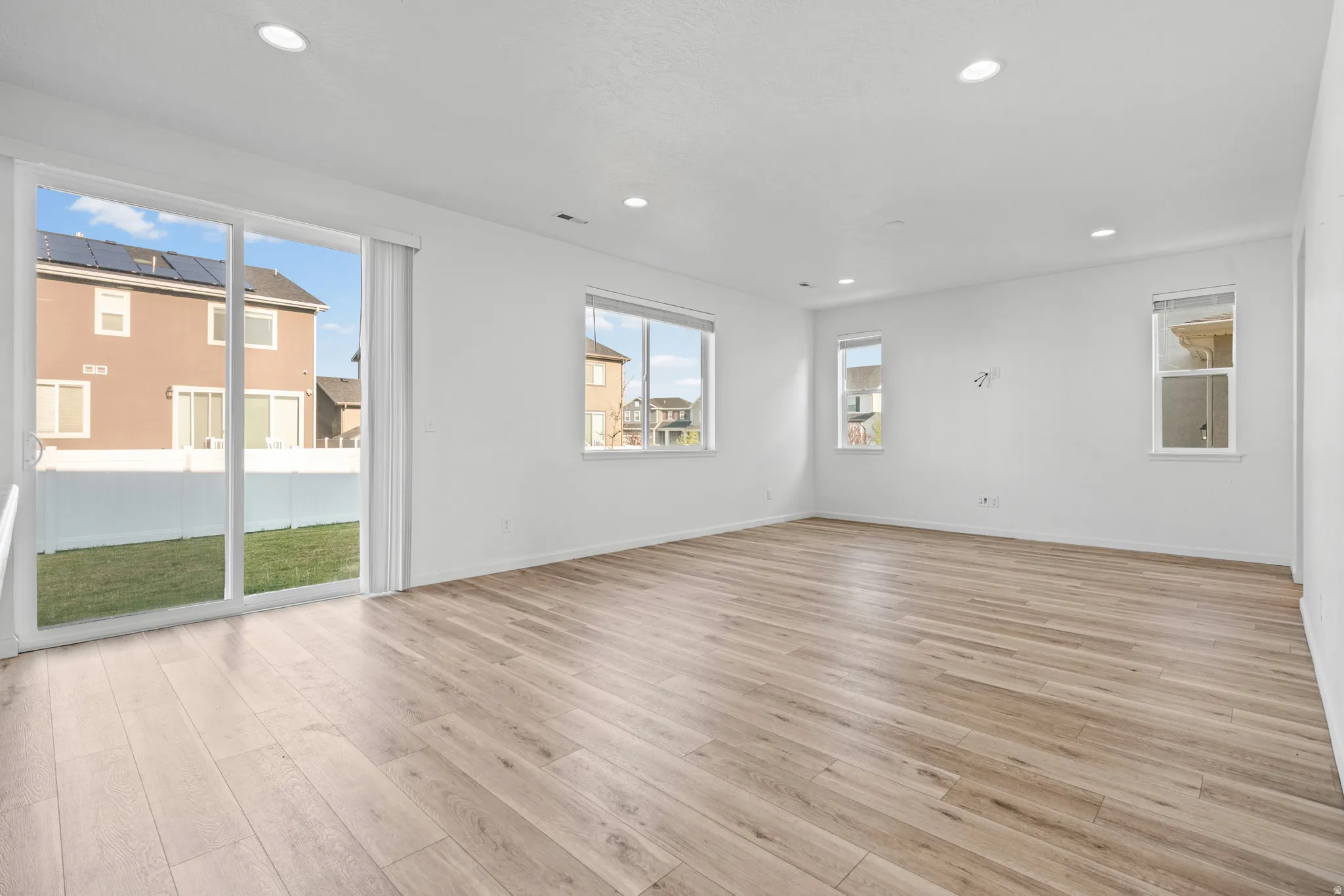 Spacious interior featuring wood-finish flooring, recessed lighting, and multiple windows