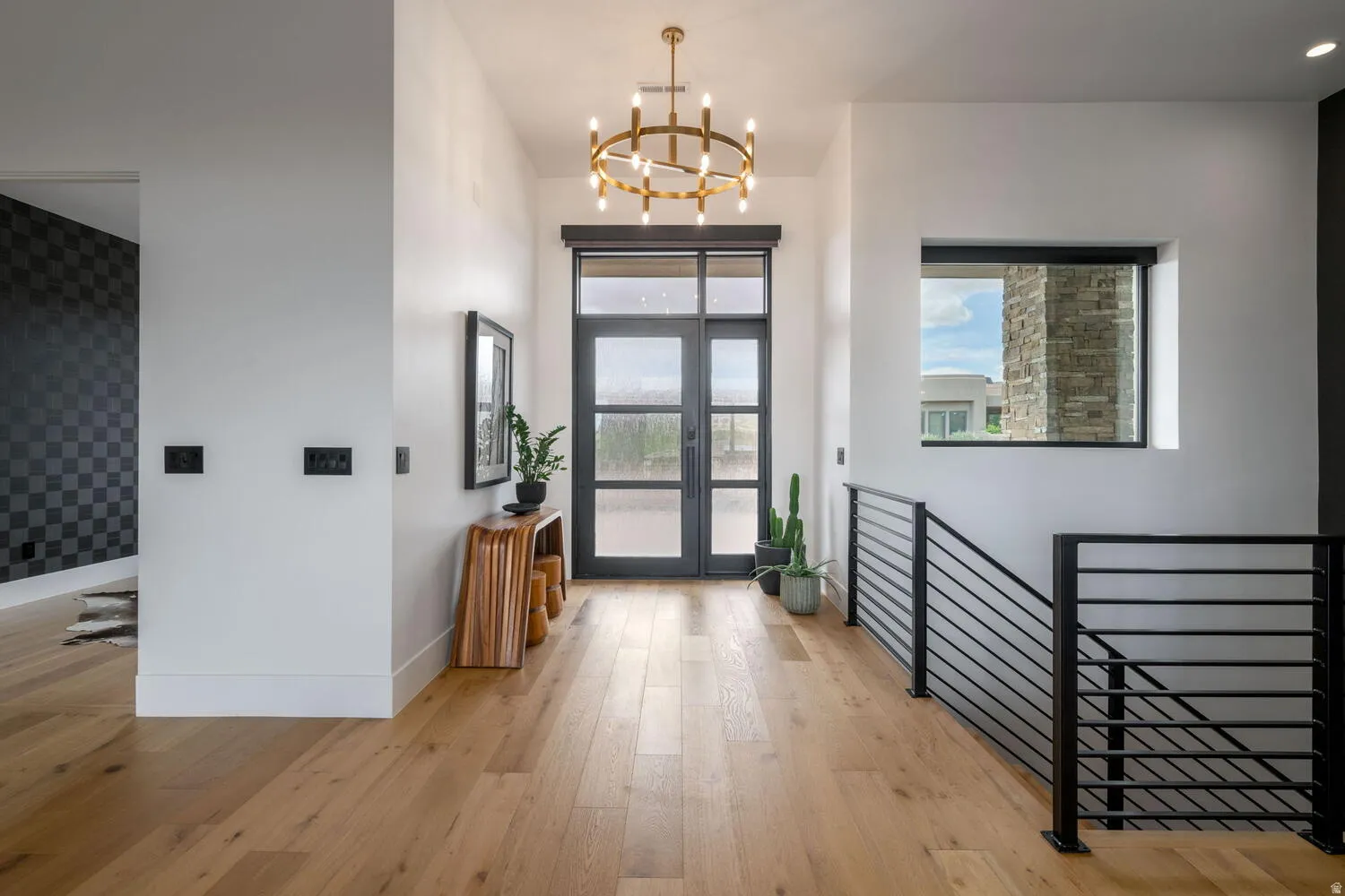 Foyer entrance featuring light wood finished floors, french doors, and a chandelier