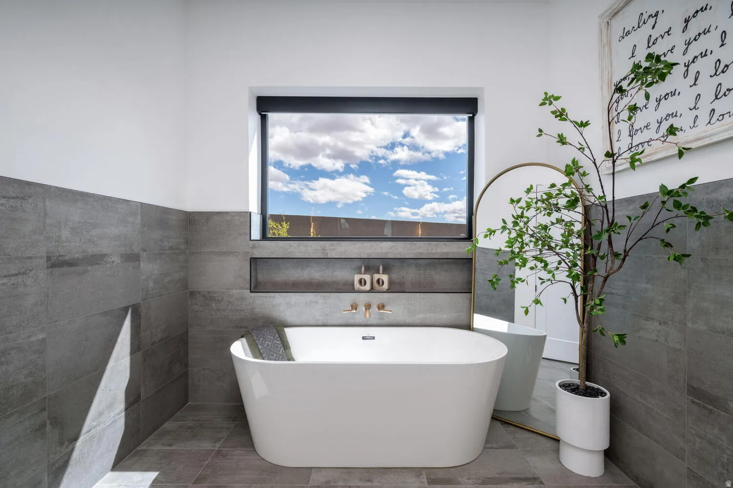 Bathroom with a freestanding tub and tile walls