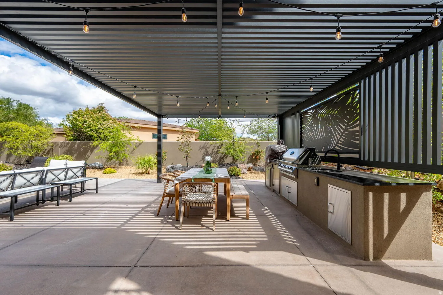 Fenced backyard featuring a patio, a pergola, and an outdoor kitchen / dining area