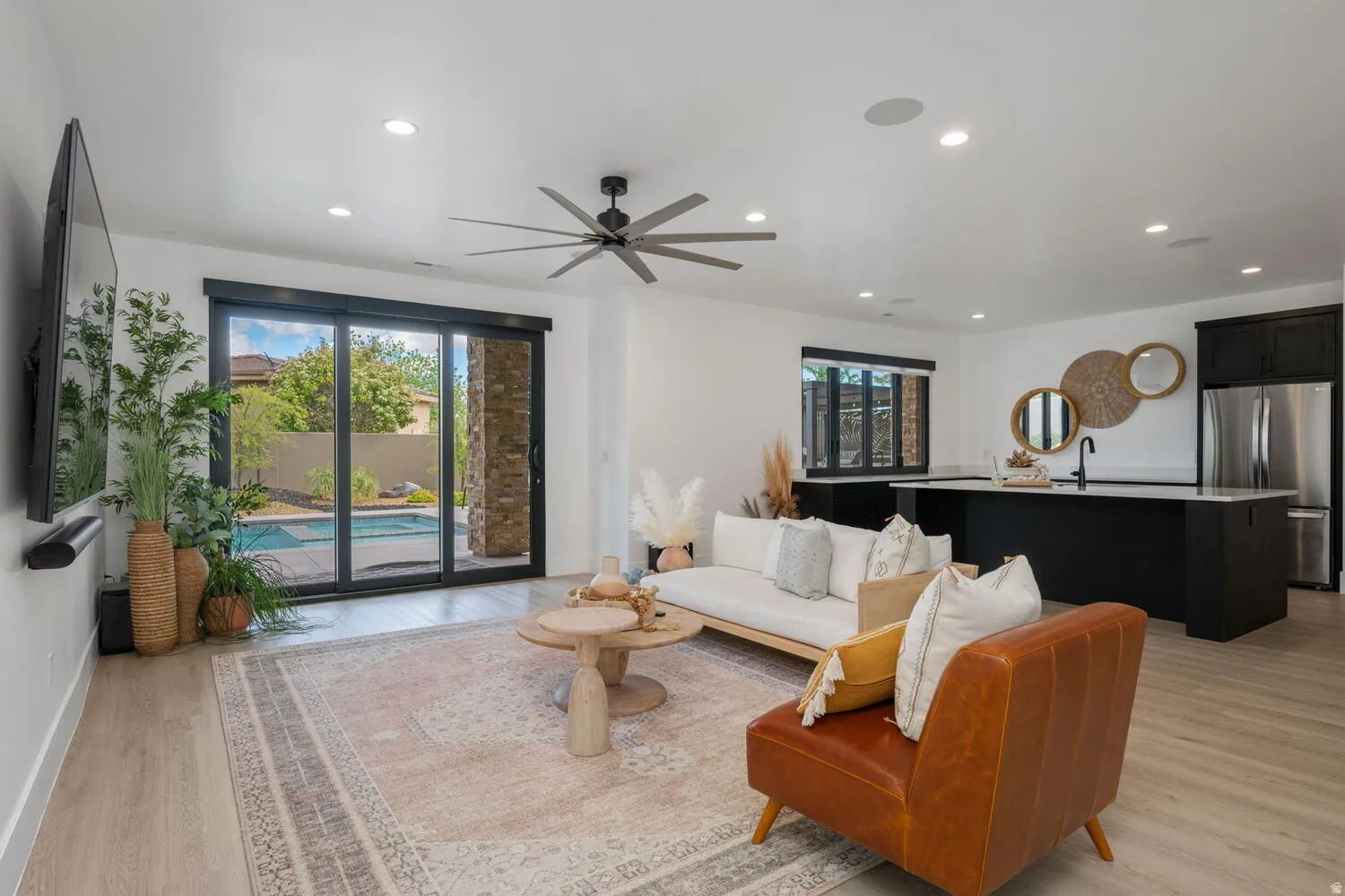 Living room with light wood-type flooring, a ceiling fan, and recessed lighting