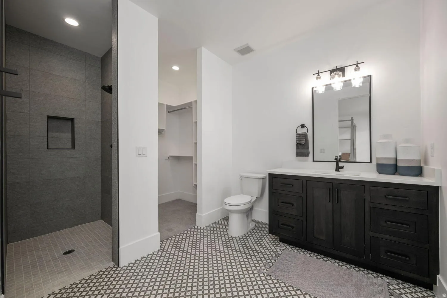 Full bathroom with vanity, a shower stall, a walk in closet, and recessed lighting