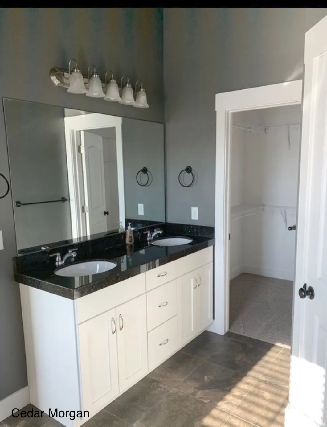 Full bath featuring double vanity and a spacious closet