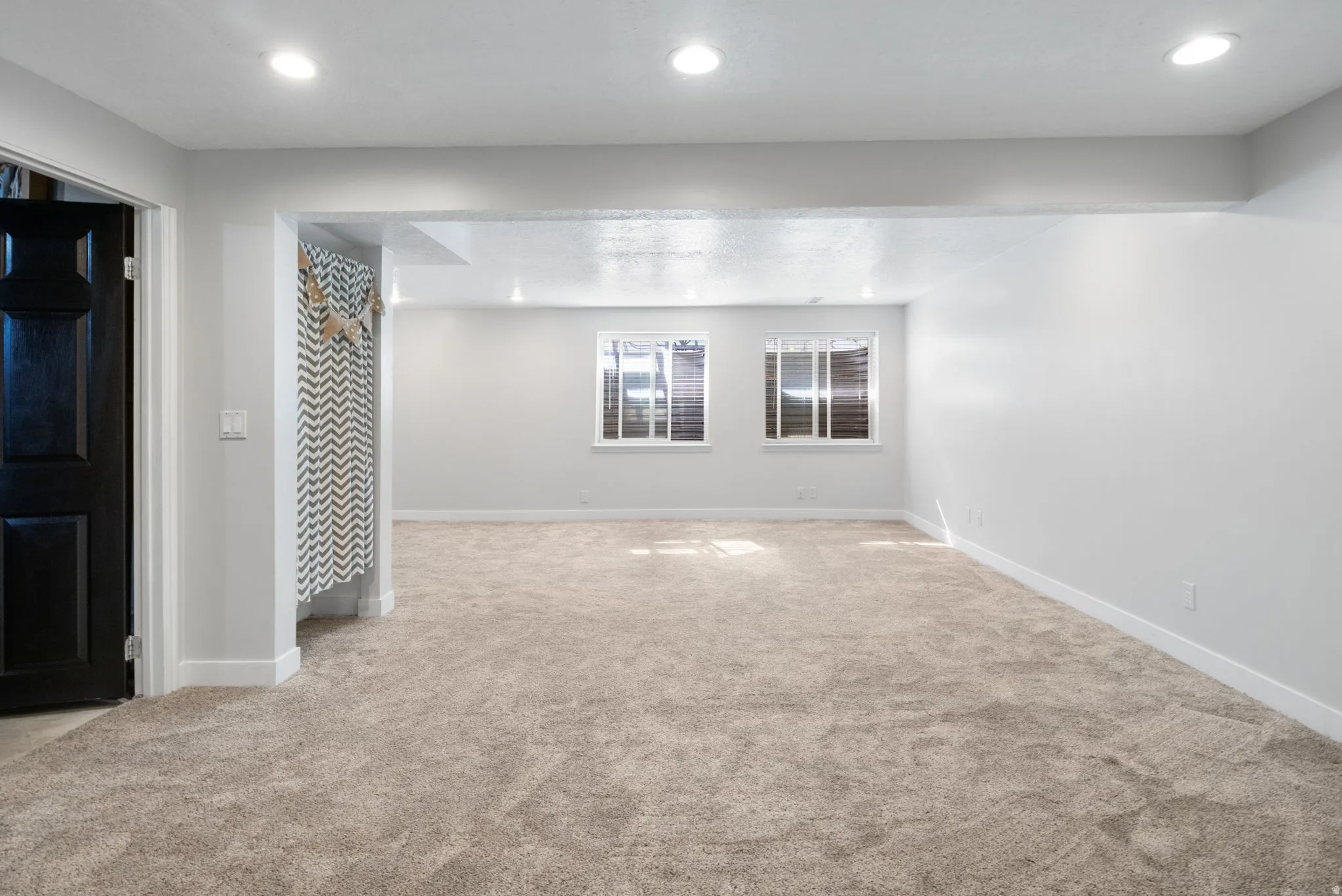 Finished Basement with light carpet and recessed lighting