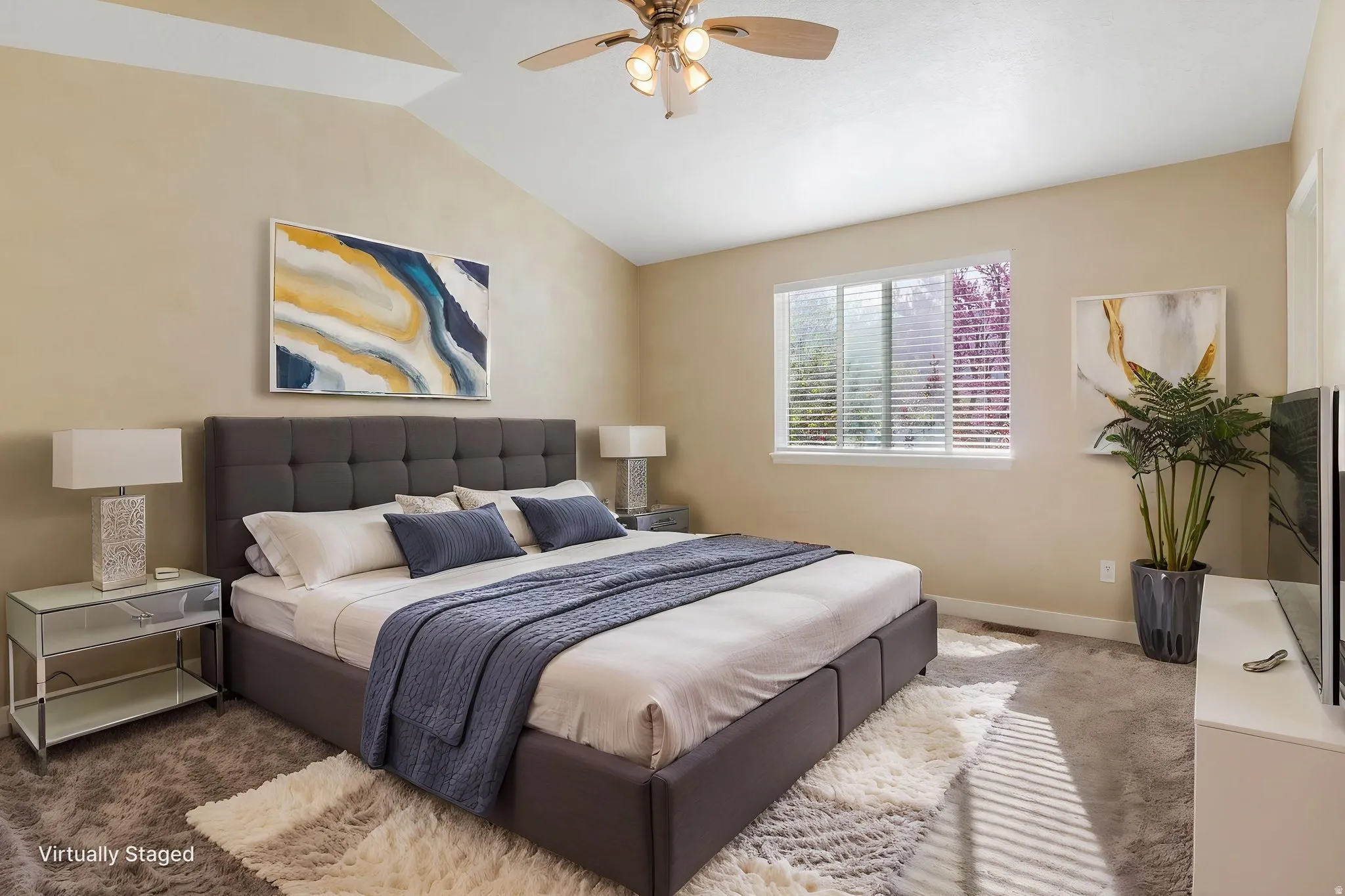 Primary bedroom with a ceiling fan and vaulted ceiling