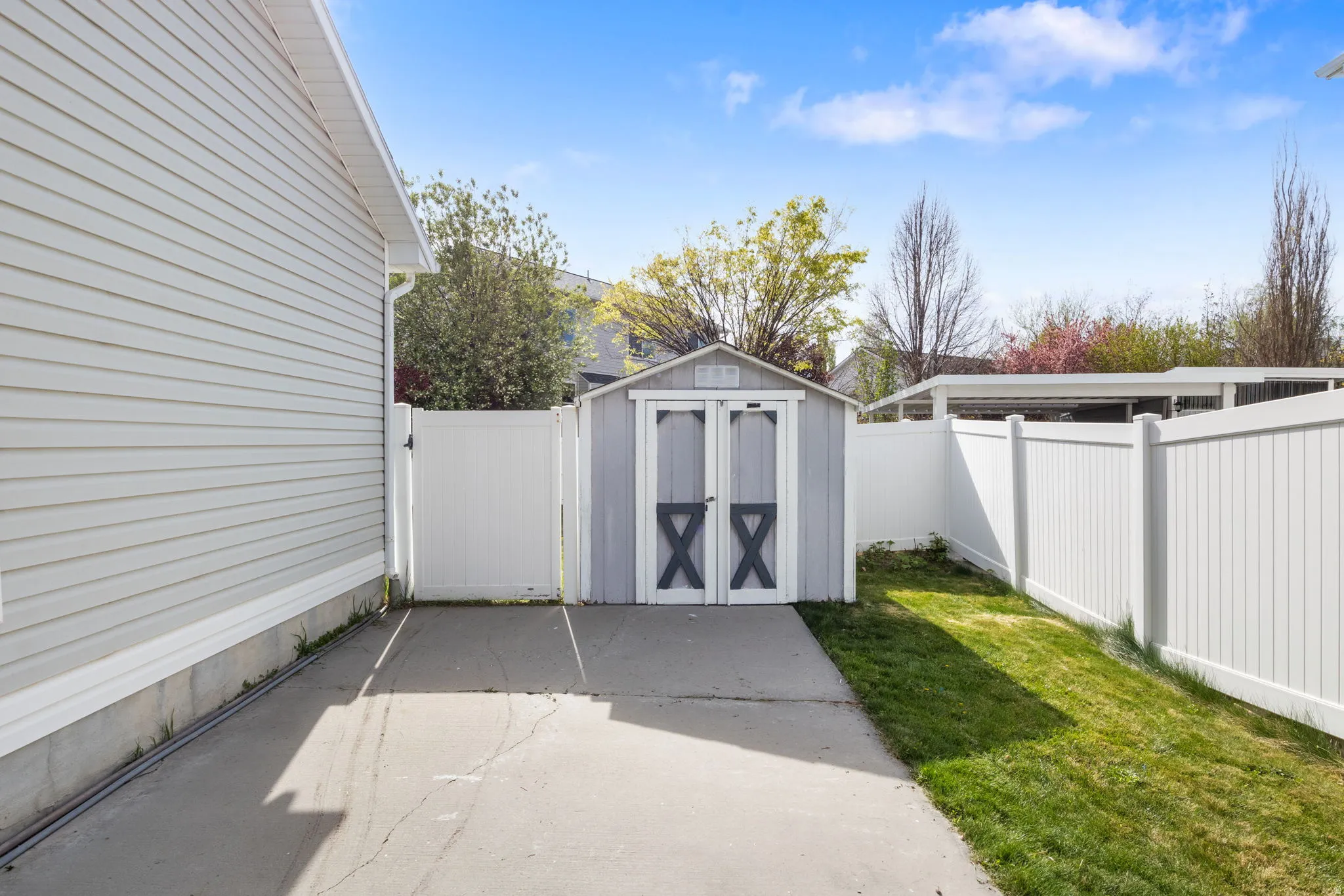View of shed with a fenced backyard and a gate