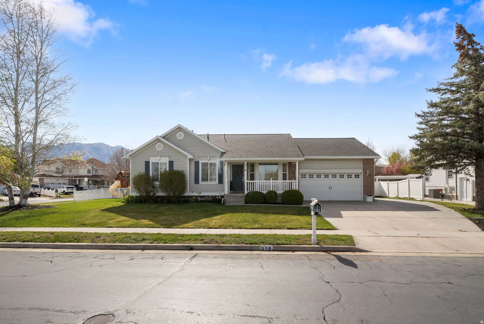 View of front of home featuring covered porch, concrete driveway, a garage, a mountain view, and roof with shingles