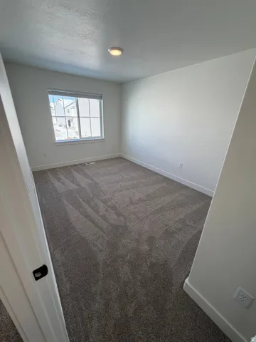 Spare room with dark colored carpet and a textured ceiling