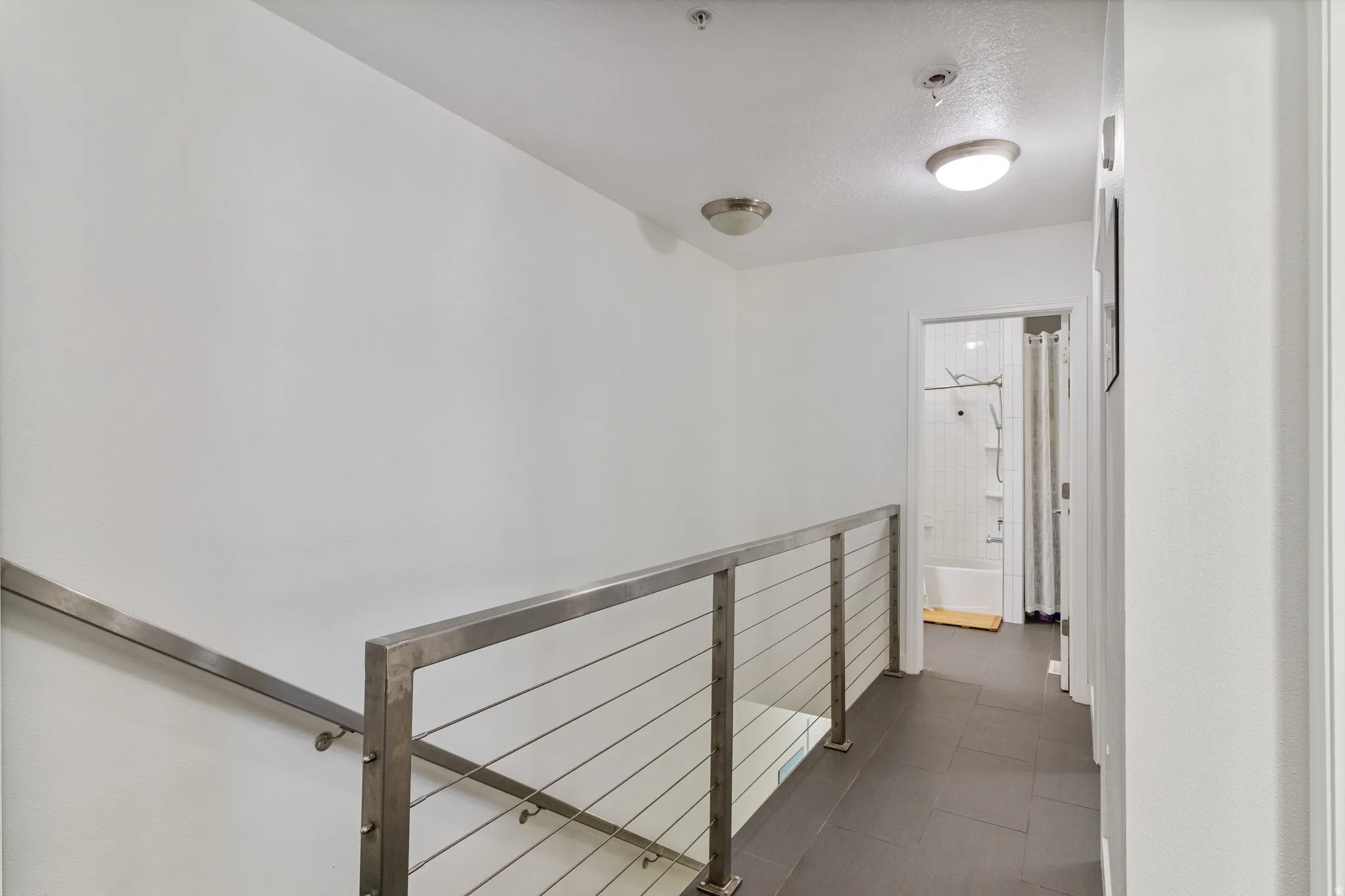 Hall featuring dark tile patterned floors.