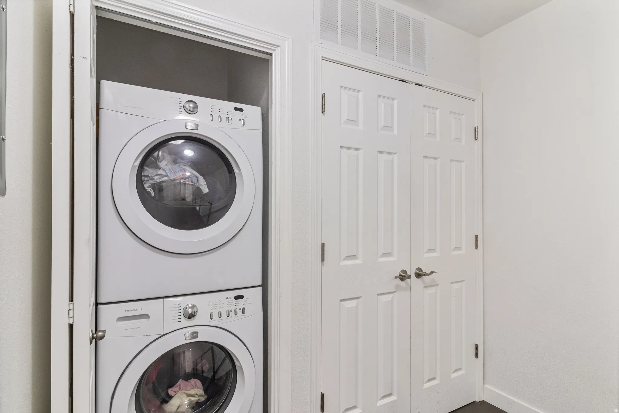 Laundry area with stacked washer and dryer.