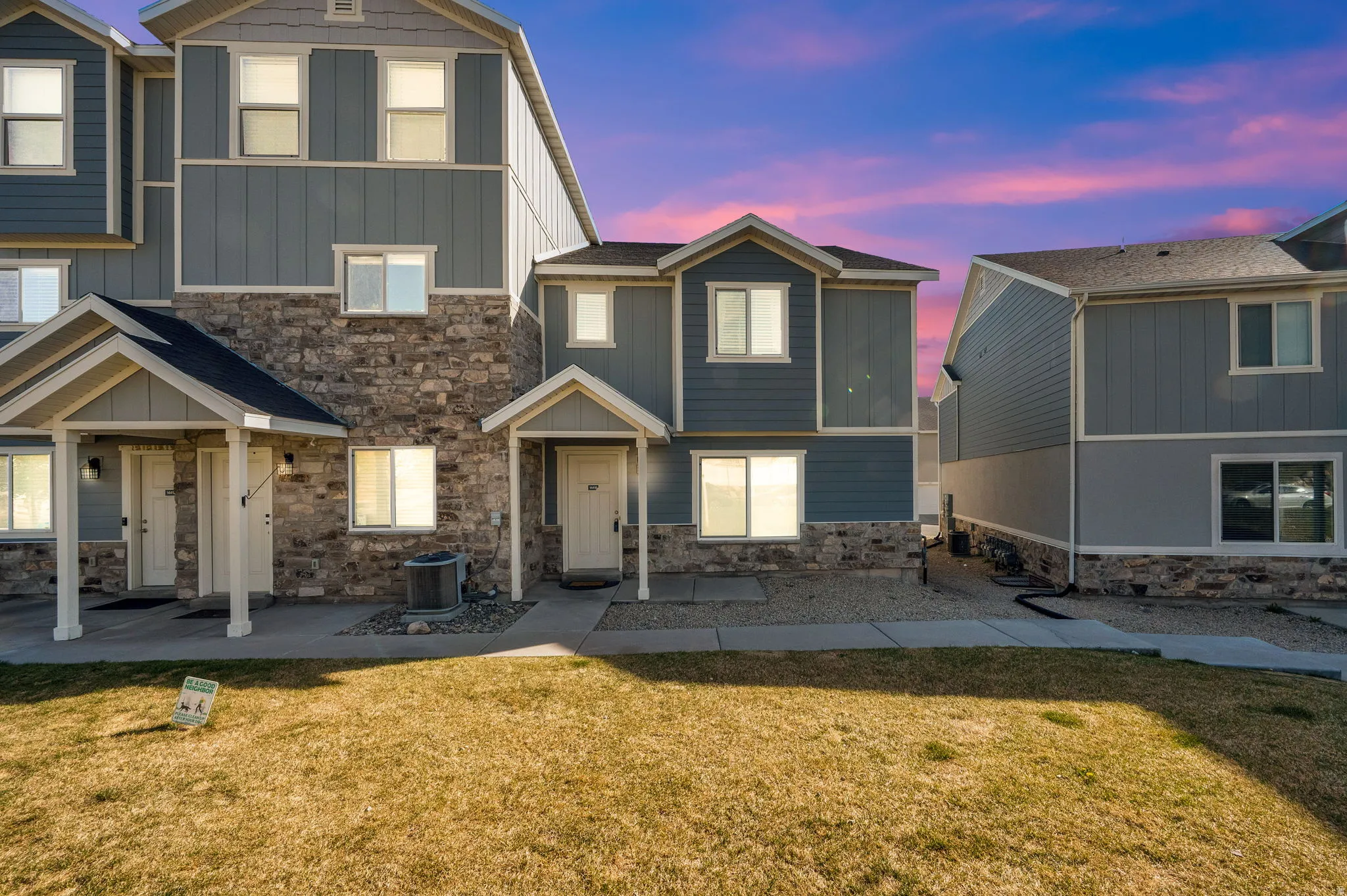 View of front of house with a front yard, stone siding, and board and batten siding