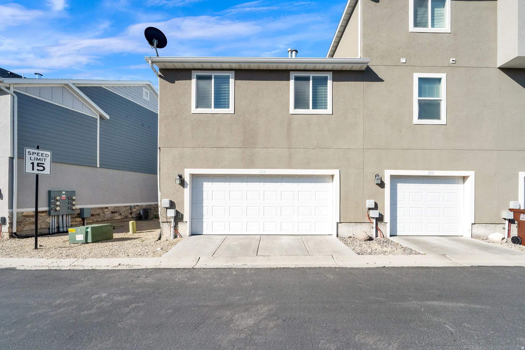 View of front of house with stucco siding, an attached garage, and driveway