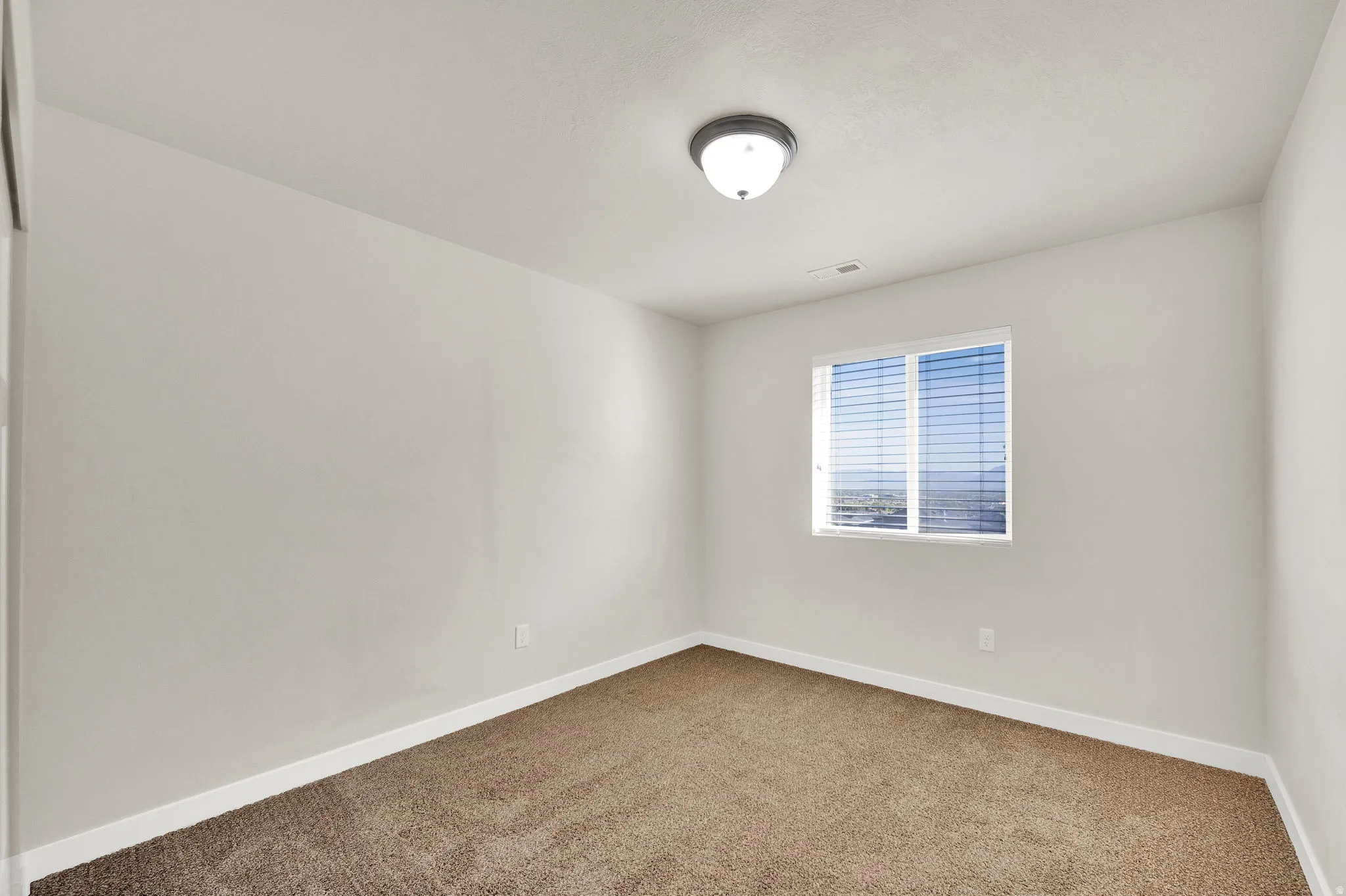 Carpeted spare room featuring baseboards