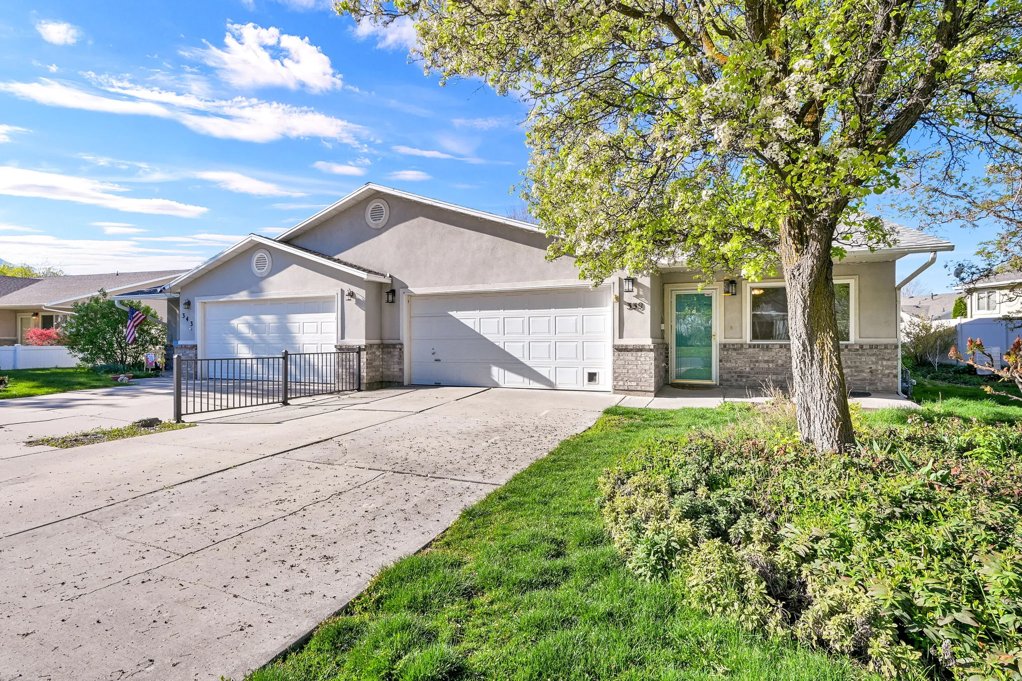 View of front of home featuring concrete driveway, an attached garage, stucco siding, and brick siding