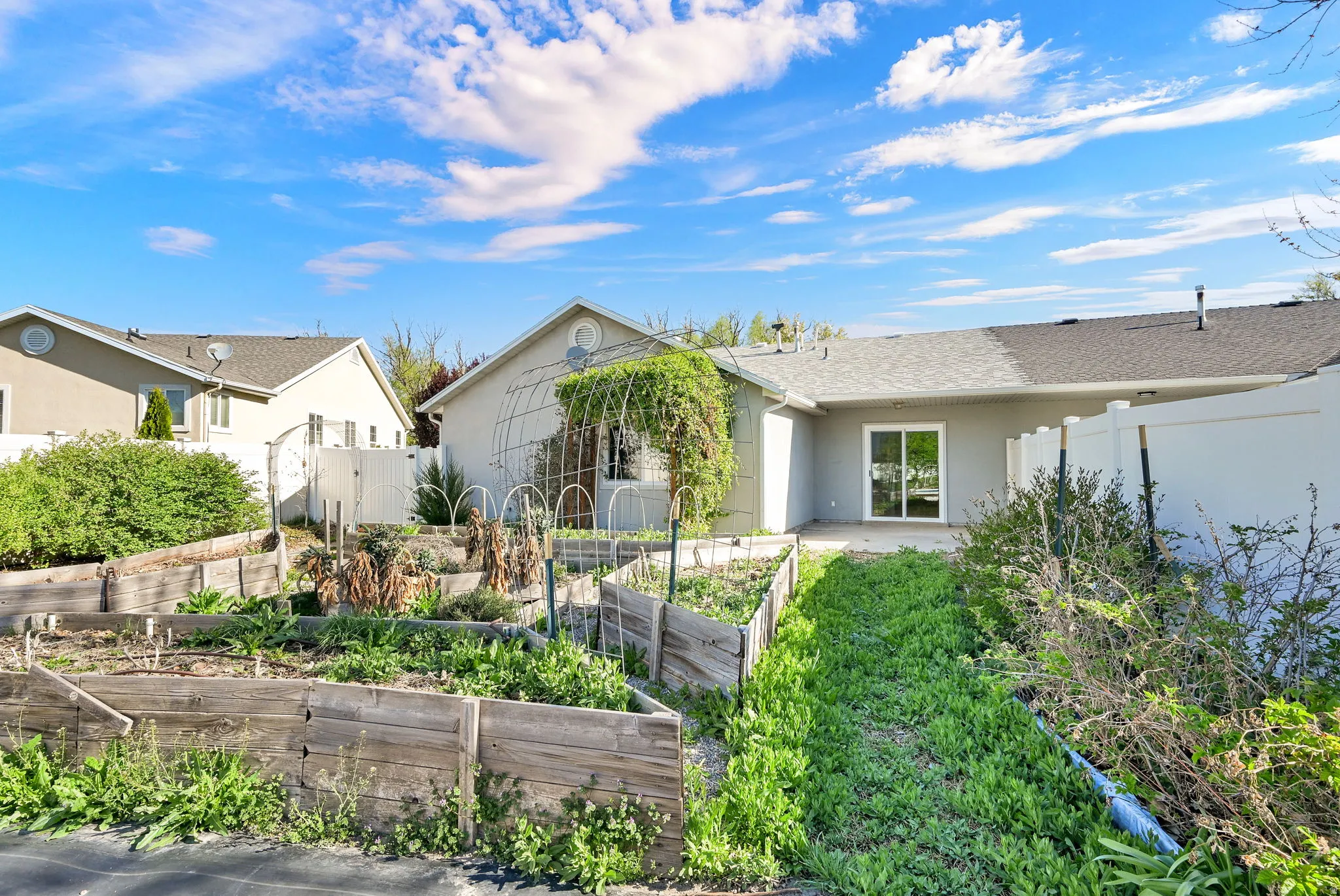 Rear view of house featuring a patio, a vegetable garden, and tons of creative space.