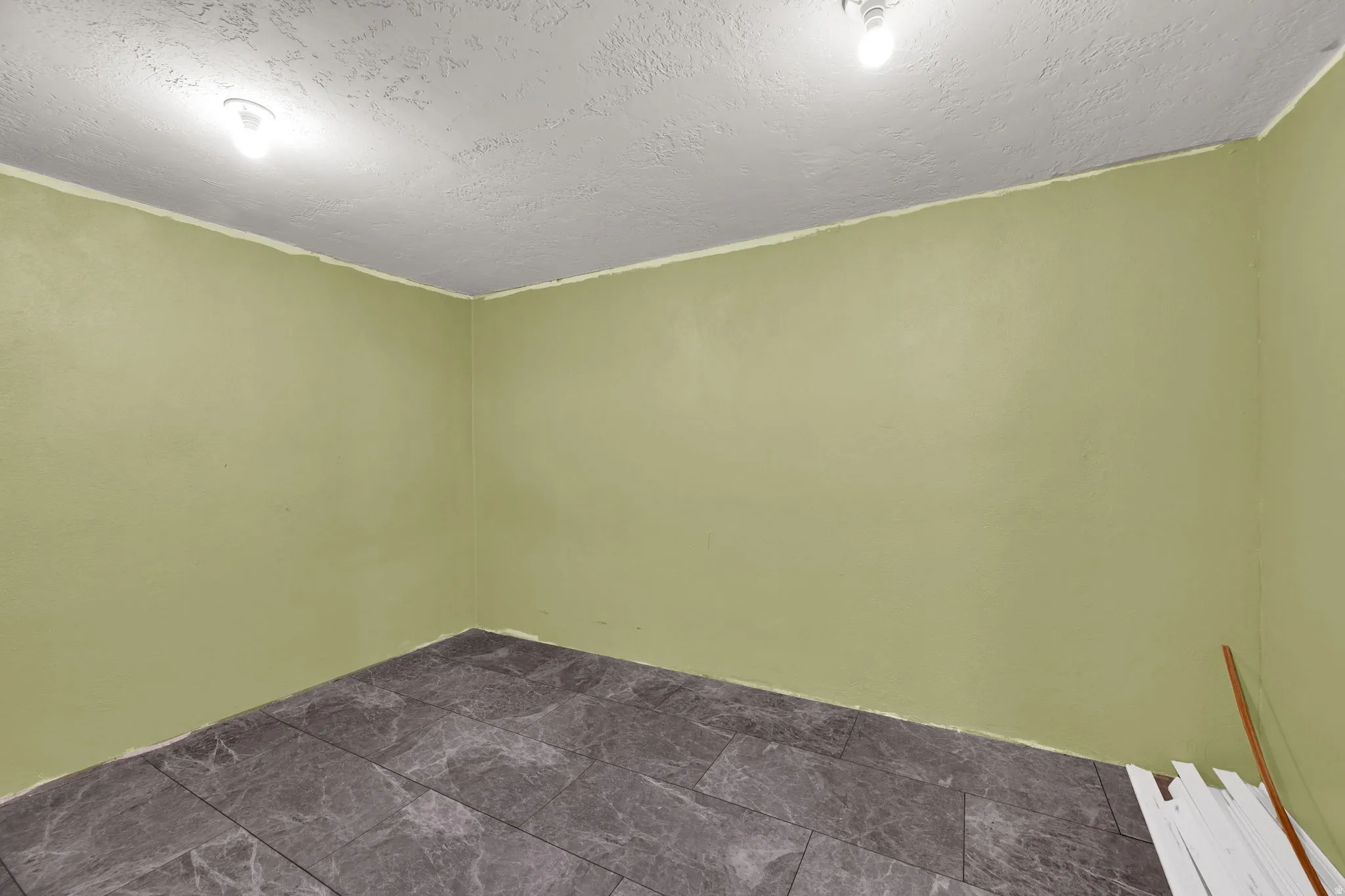 Spare room with a textured ceiling and dark stone finish floors