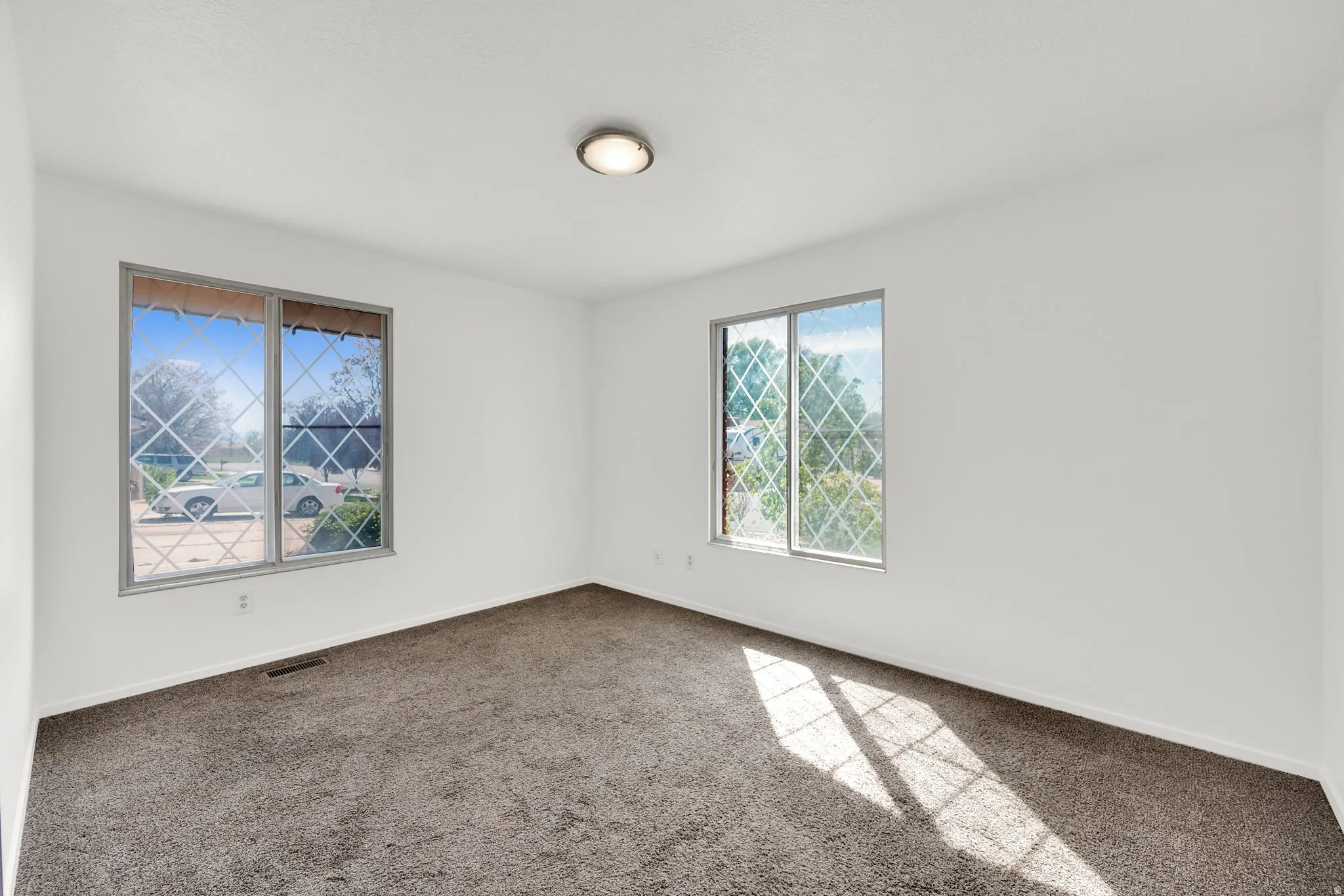 Spare room with baseboards and dark carpet