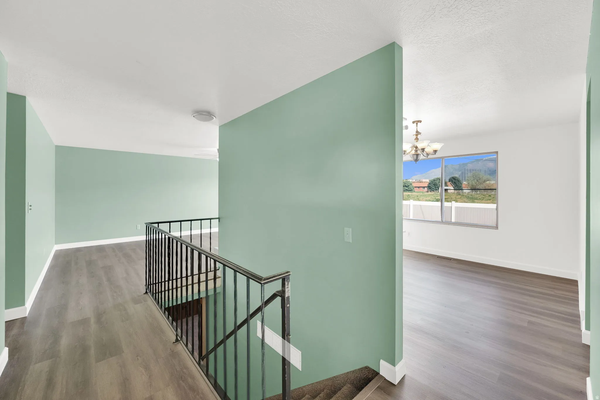Stairs featuring suspended lighting and wood finished floors