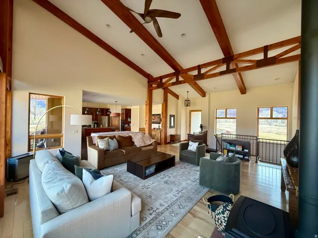 Living area with light wood-style flooring, ceiling fan, vaulted ceiling, and recessed lighting