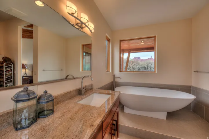 Bathroom with vanity, wainscoting, tile walls, and a soaking tub