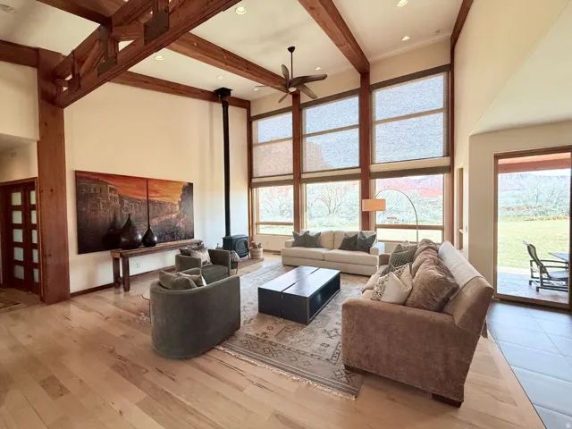 Living area with a wood stove, light wood-type flooring, a ceiling fan, and recessed lighting