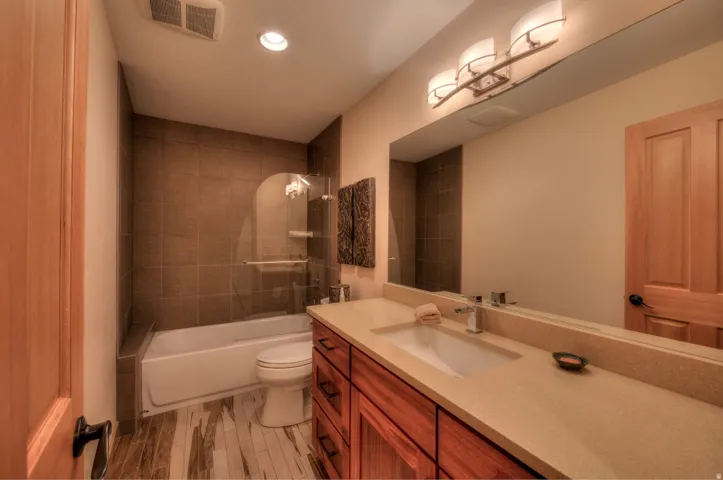 Bathroom with vanity, shower / bath combination, recessed lighting, and light wood-type flooring