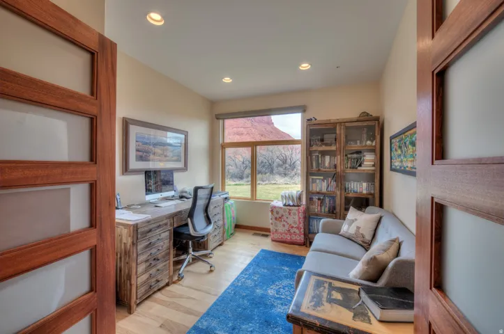 Office area featuring light wood-style floors and recessed lighting