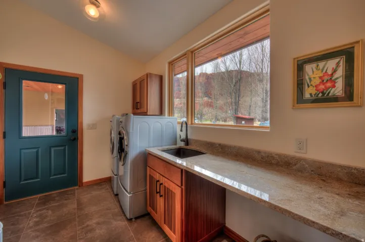 Laundry area with vaulted ceiling, washer and dryer, and cabinet space