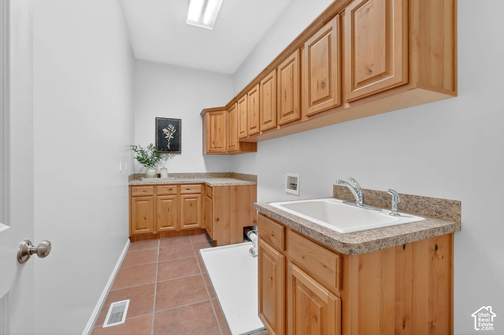 Laundry area featuring hookup for a washing machine, cabinet space, and light tile patterned flooring