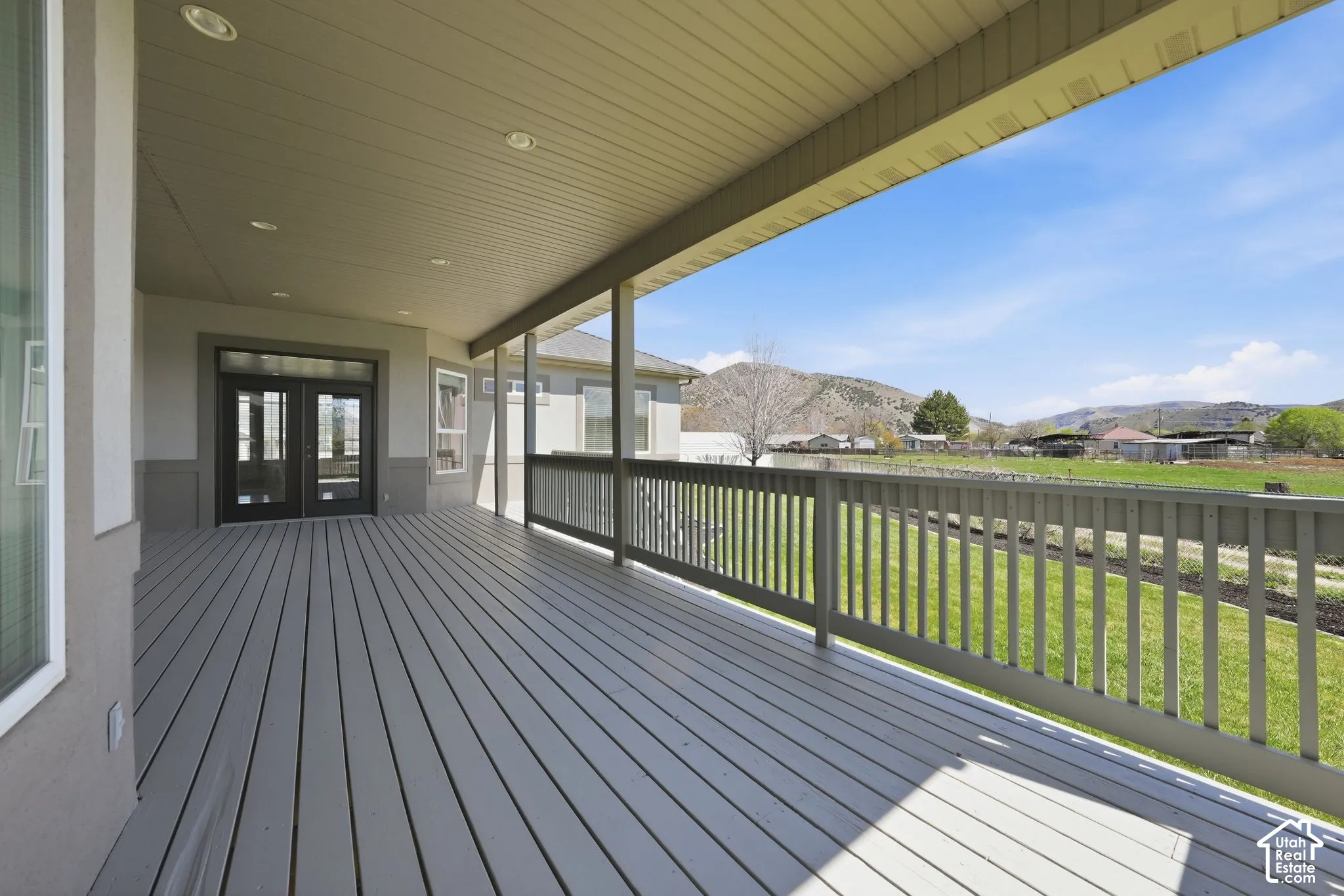 Wooden terrace with a residential view, french doors, and a mountain view