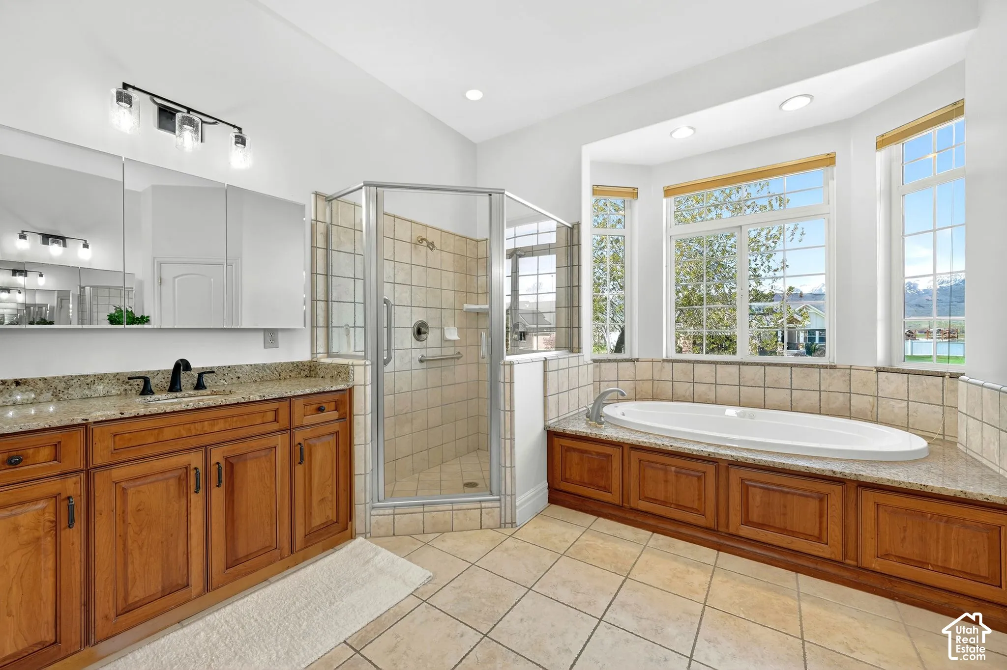 Bathroom featuring a shower stall, a garden tub, light tile patterned floors, vanity, and recessed lighting
