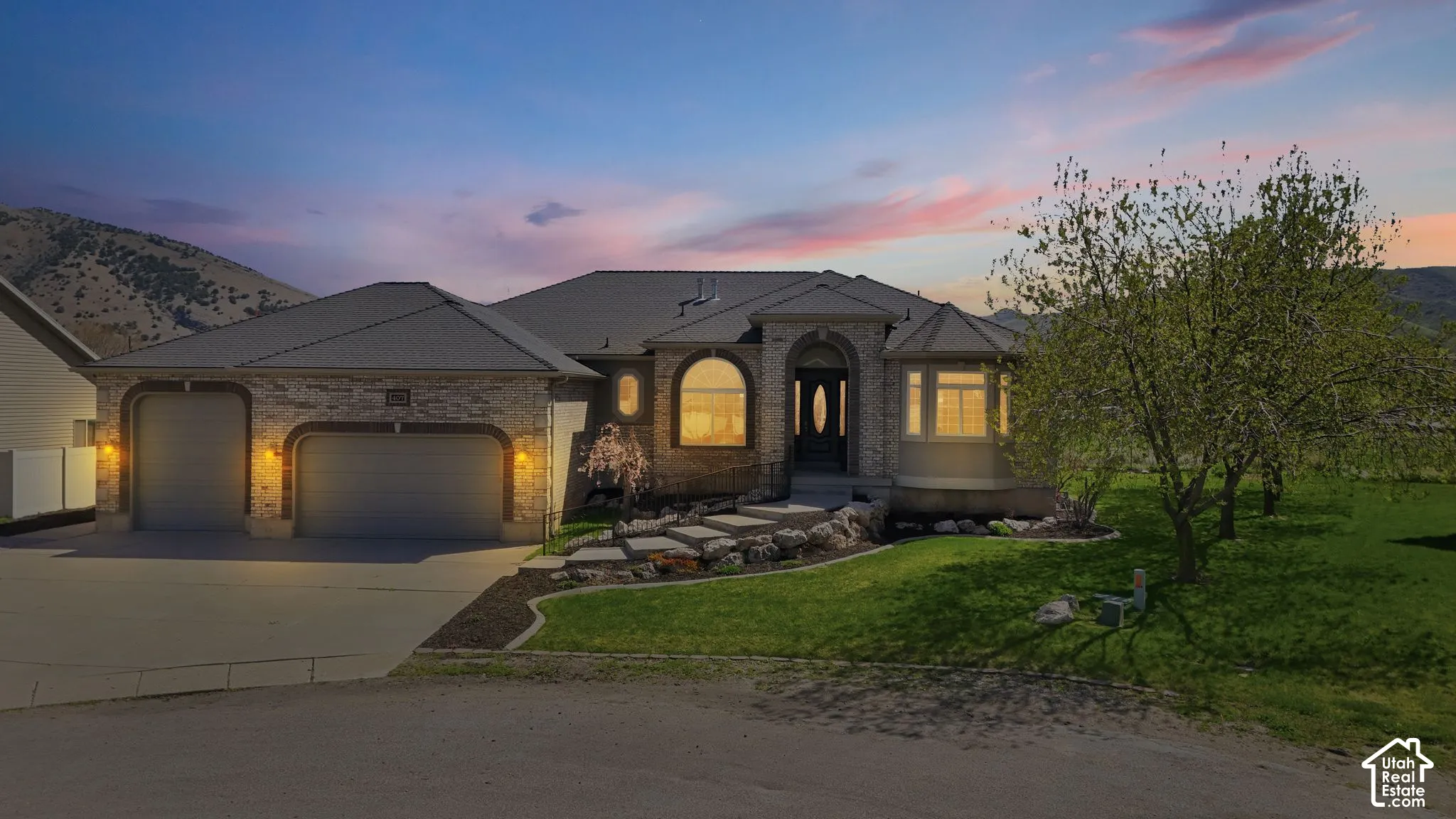 French country inspired facade featuring a yard, a garage, driveway, and brick siding