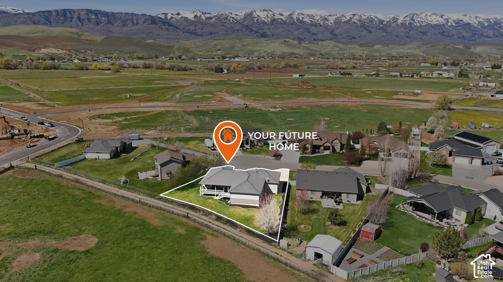 Aerial view of property's location with property boundaries highlighted, a mountainous background, and nearby suburban area