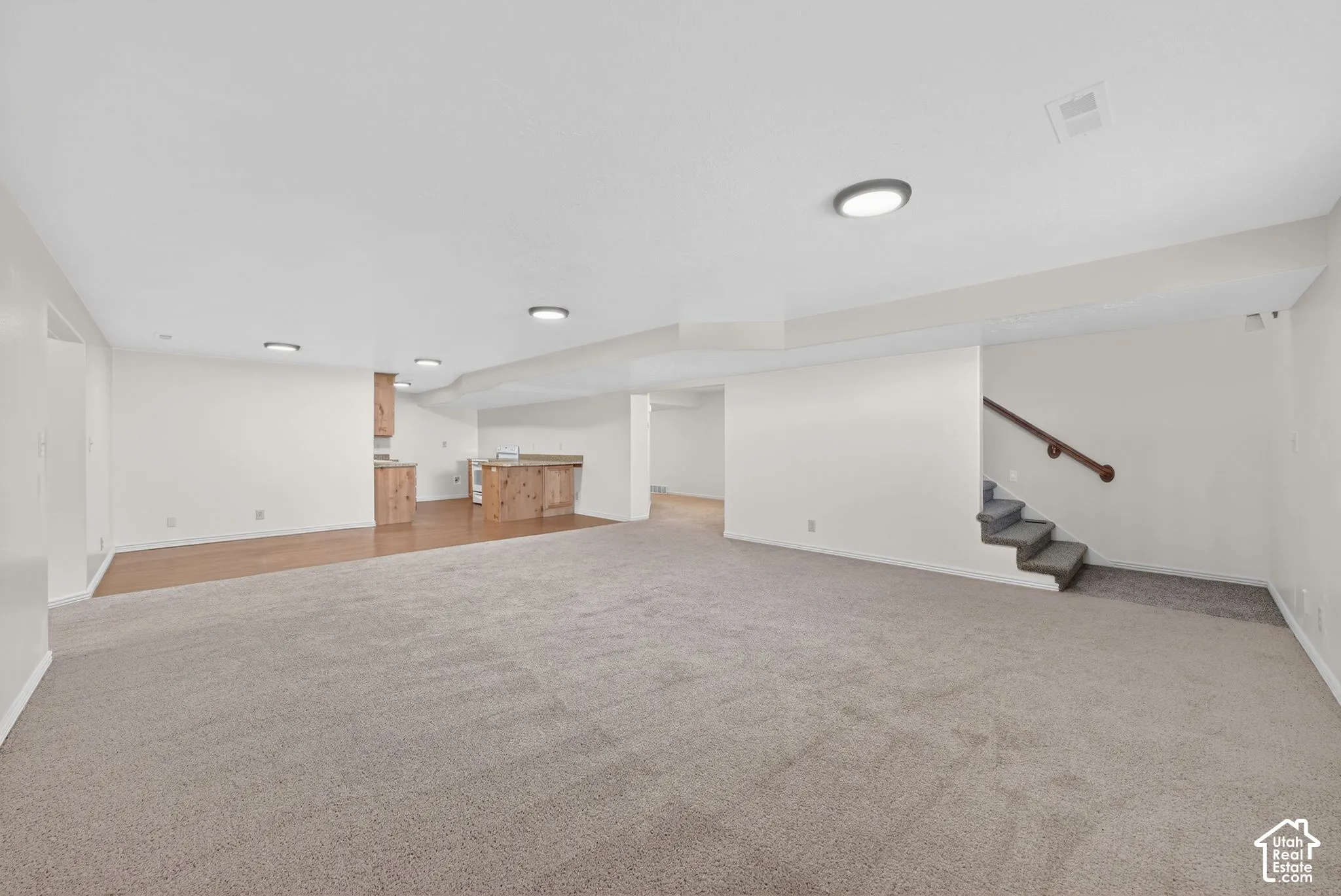 Finished basement featuring stairway and light carpet