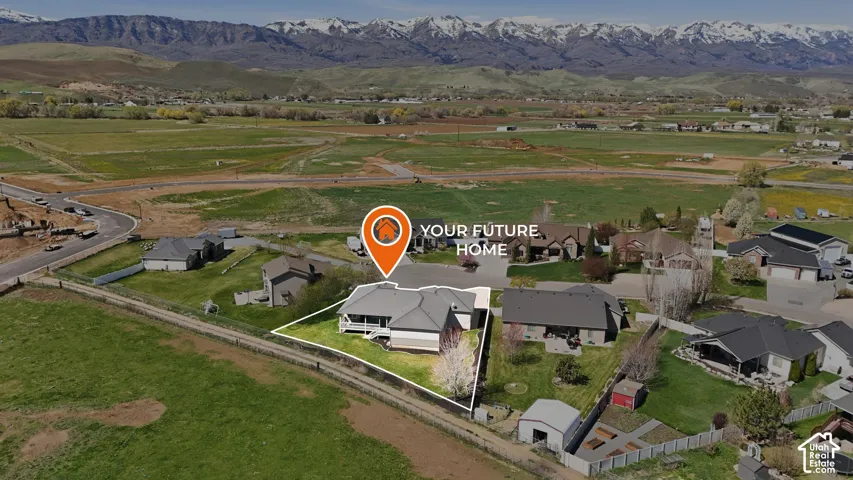 Aerial view of property's location with property boundaries highlighted, a mountainous background, and nearby suburban area