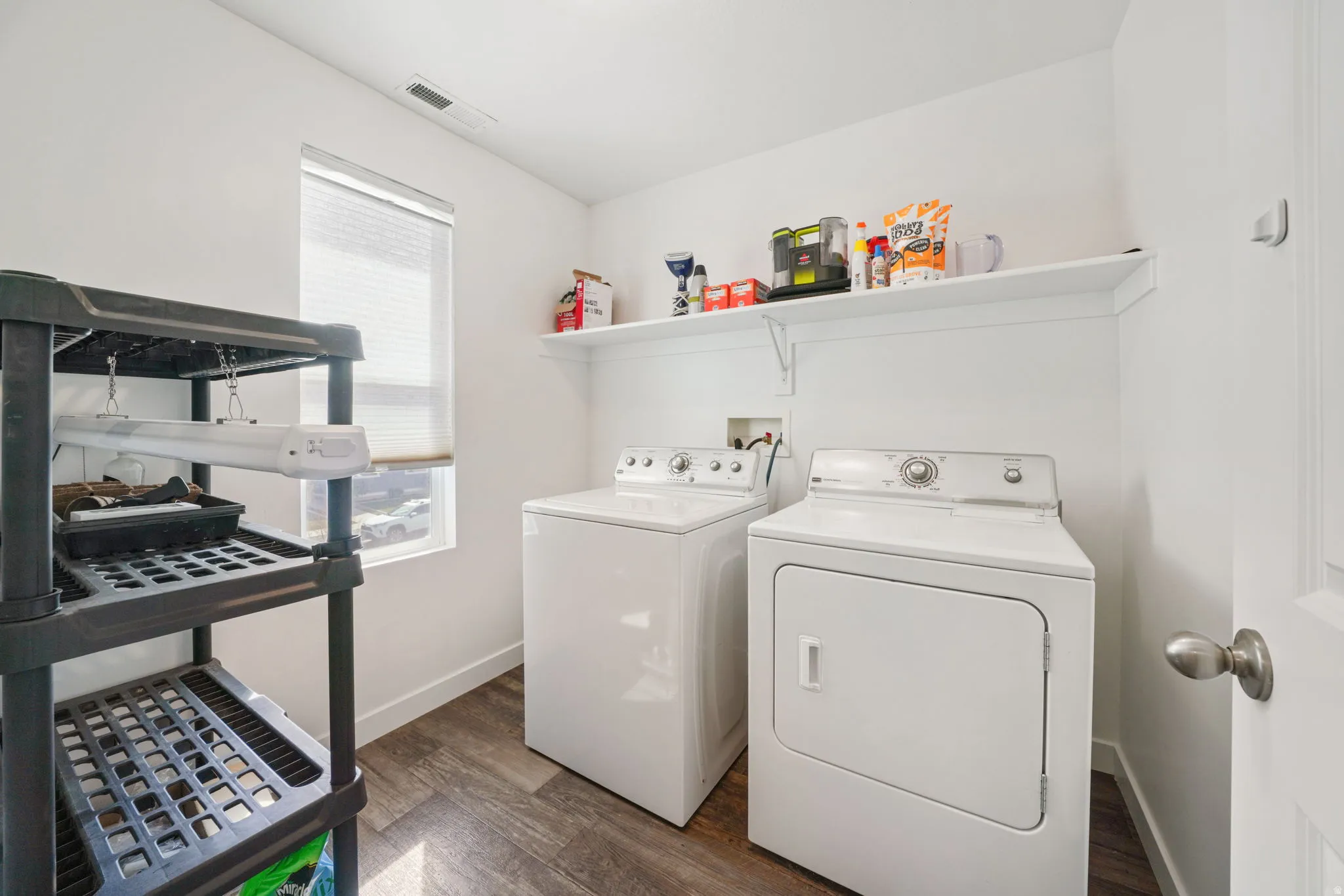 Laundry area featuring dark wood finished floors and independent washer and dryer