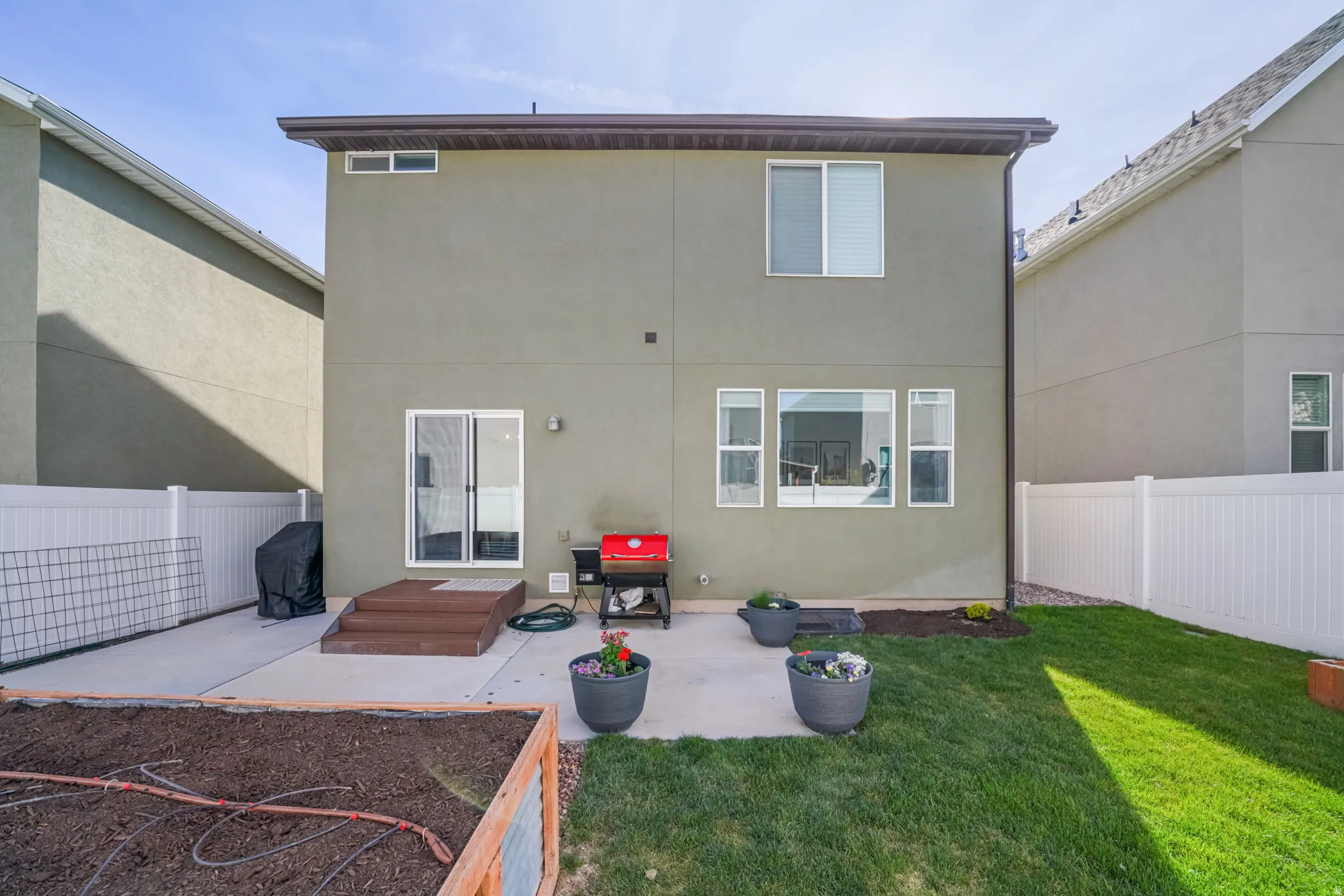 Back of house with a fenced backyard, a patio area, and stucco siding