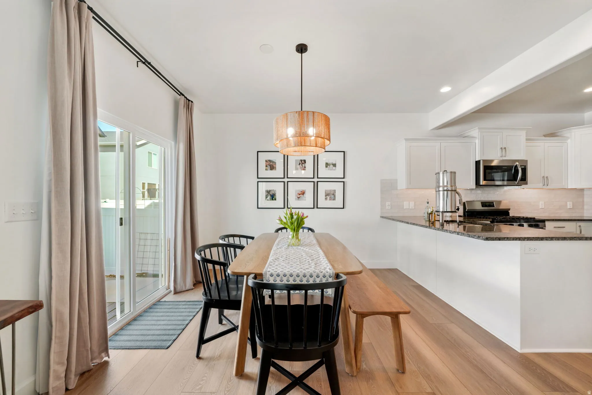 Dining area with light wood finished floors, beam ceiling, and recessed lighting