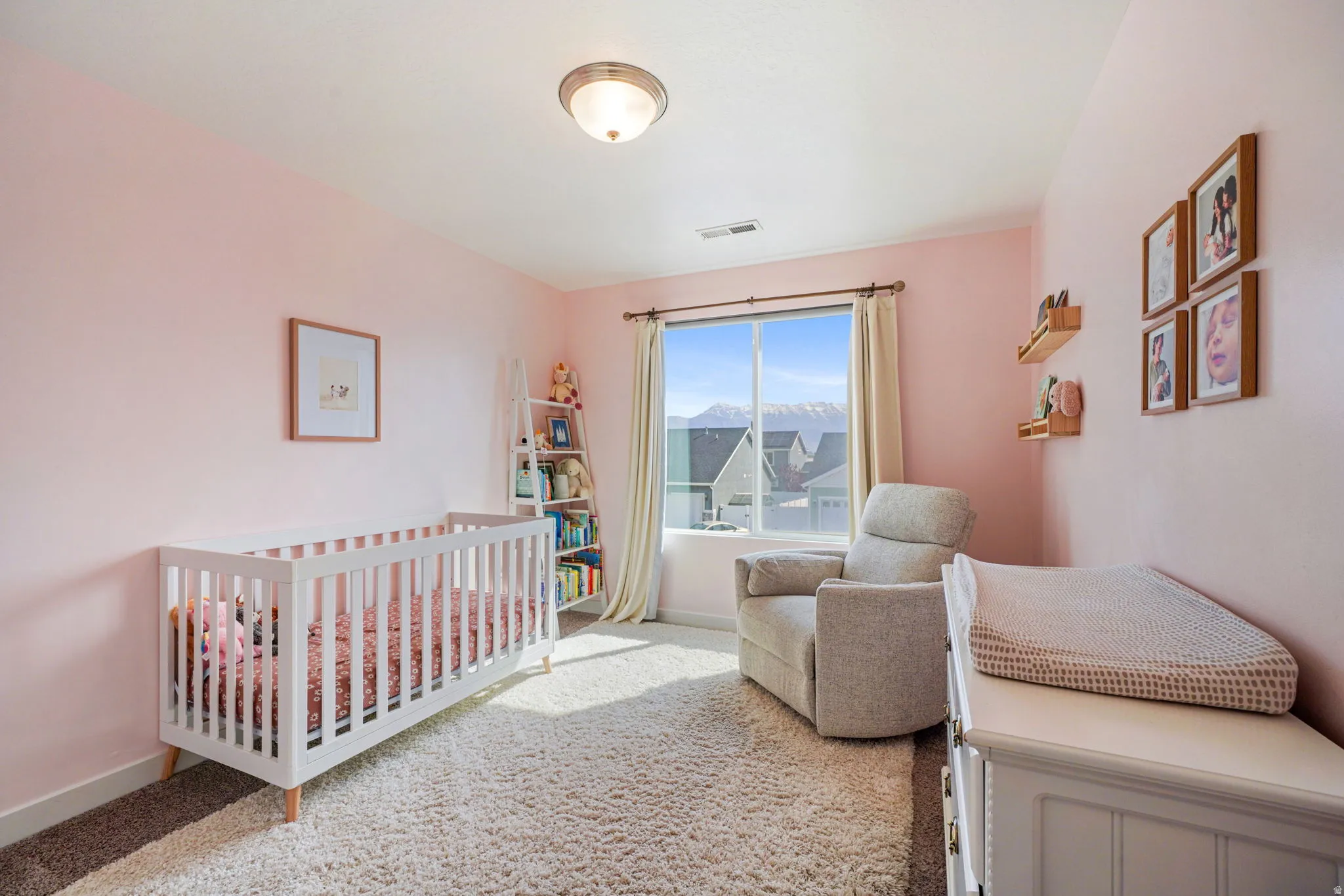 Bedroom with a nursery area and light carpet