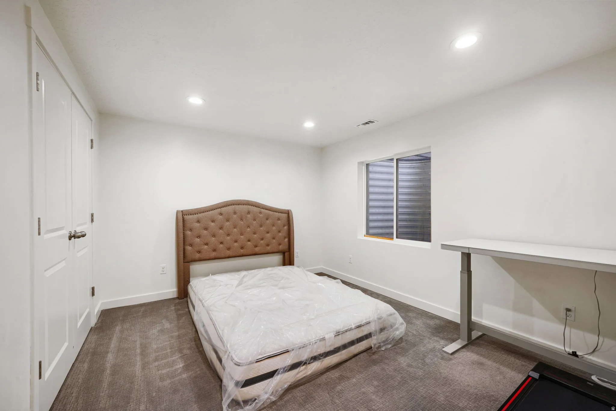 Bedroom featuring dark colored carpet, recessed lighting, and a closet