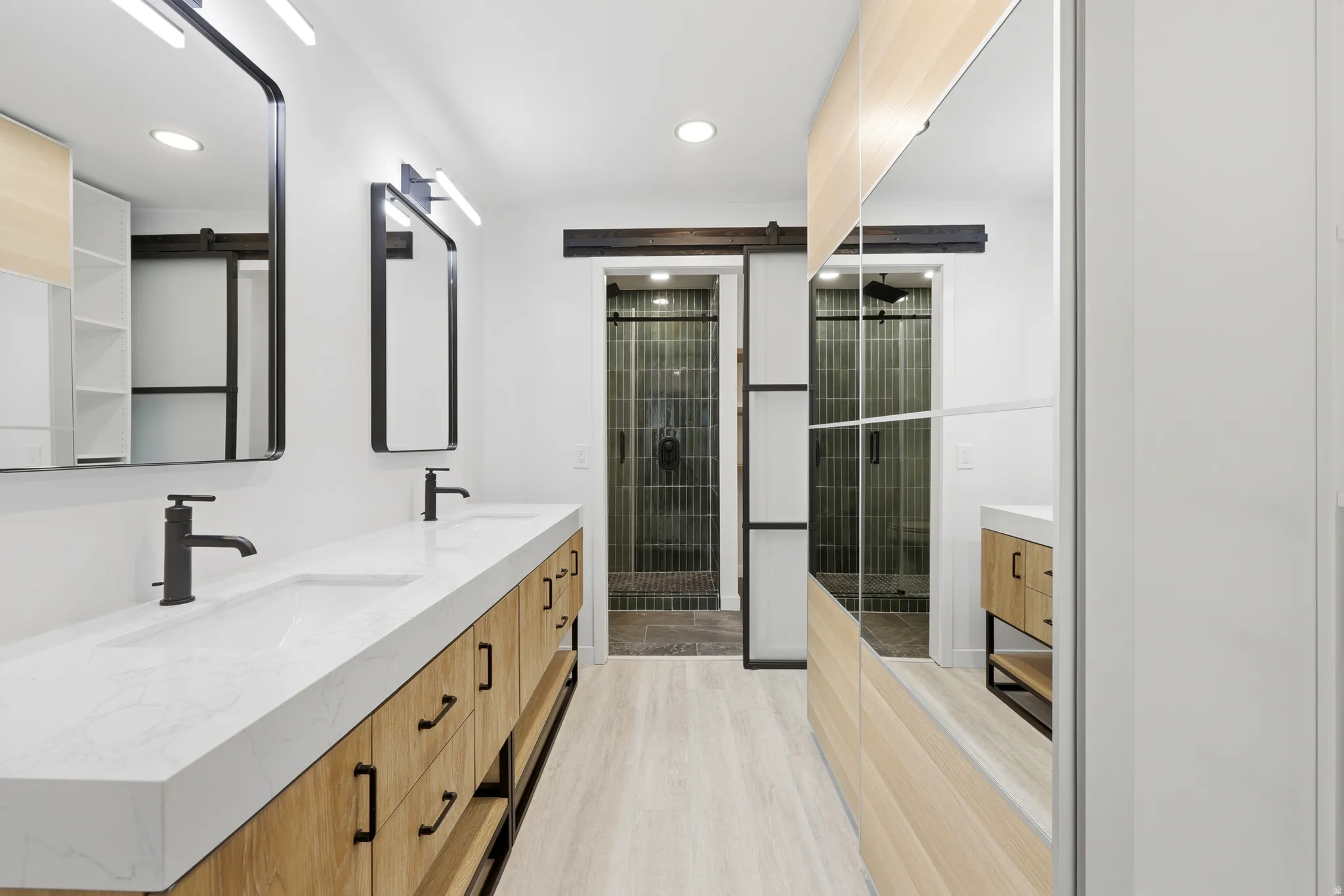 Dual vanity with integrated sinks, matte black fixtures, and closet.