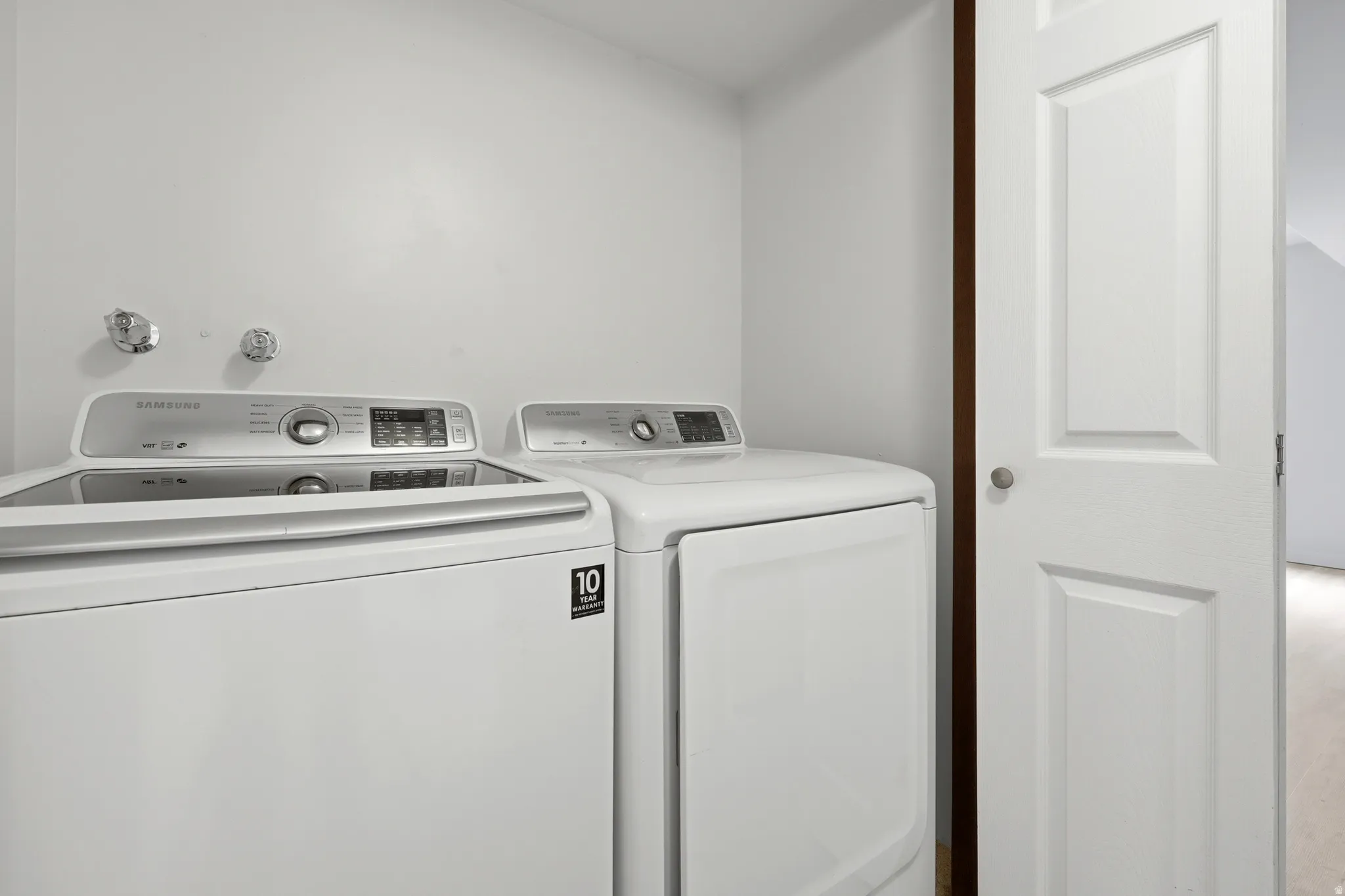 Dedicated laundry area with a top-load washing machine and front-load dryer