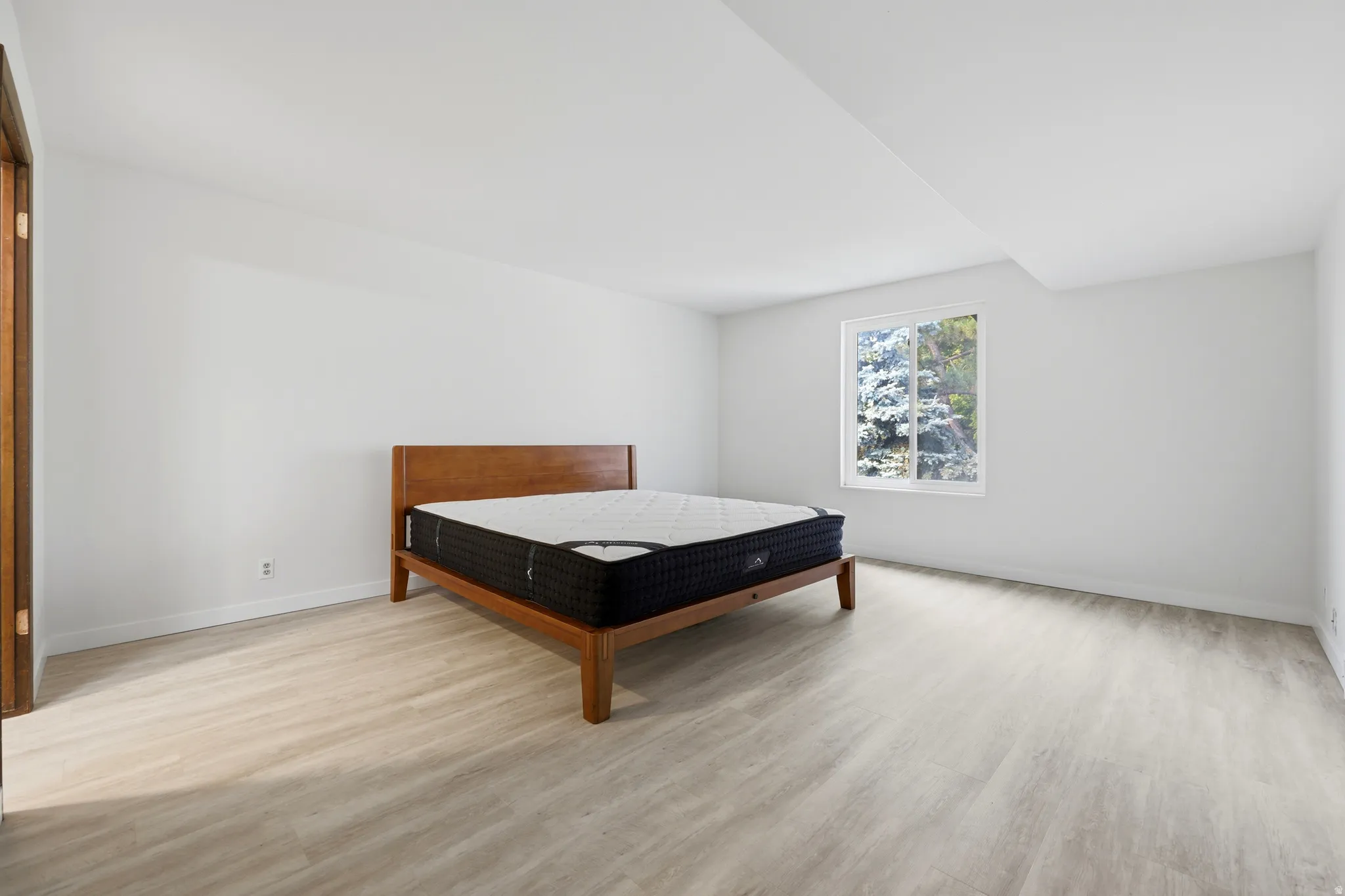 Bright interior with a single window and light wood-finish flooring