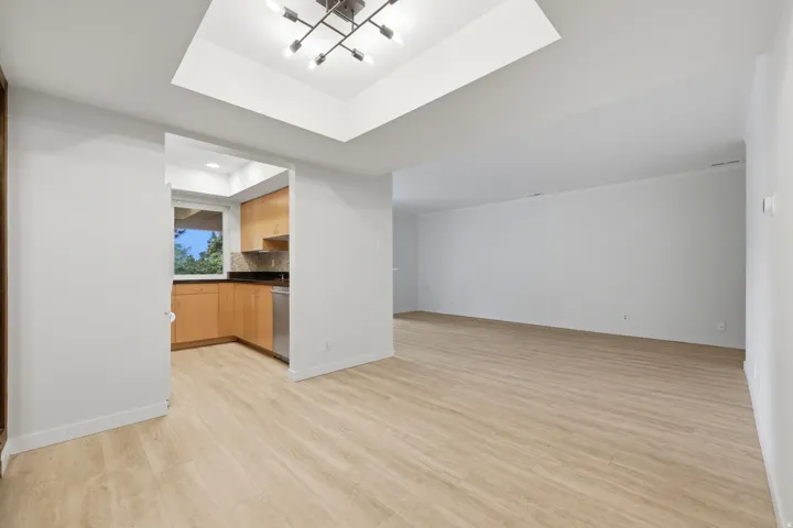 Expansive living area featuring wood-finish flooring and a contemporary chandelier