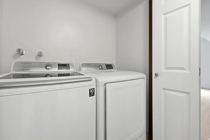 Dedicated laundry area with a top-load washing machine and front-load dryer
