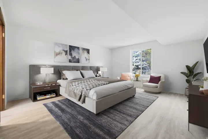 Spacious room featuring light wood-finish flooring, a large window, and light-toned walls. Virtually Staged.