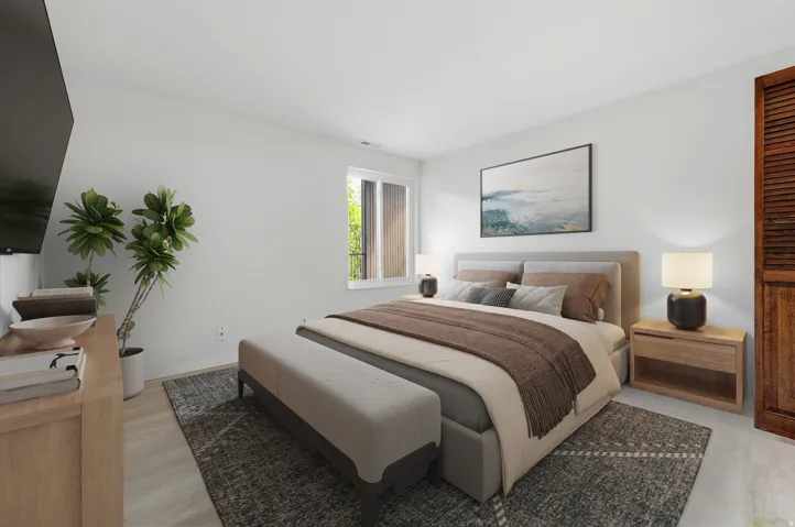 Bedroom featuring light wood-finish flooring, white walls, and a large window with exterior greenery. This room is also great for an office. Virtually Staged