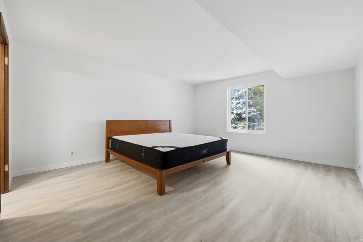 Bright interior with a single window and light wood-finish flooring