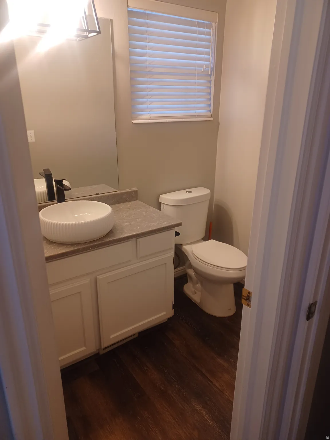Main Floor bathroom featuring vanity and dark wood finished floors